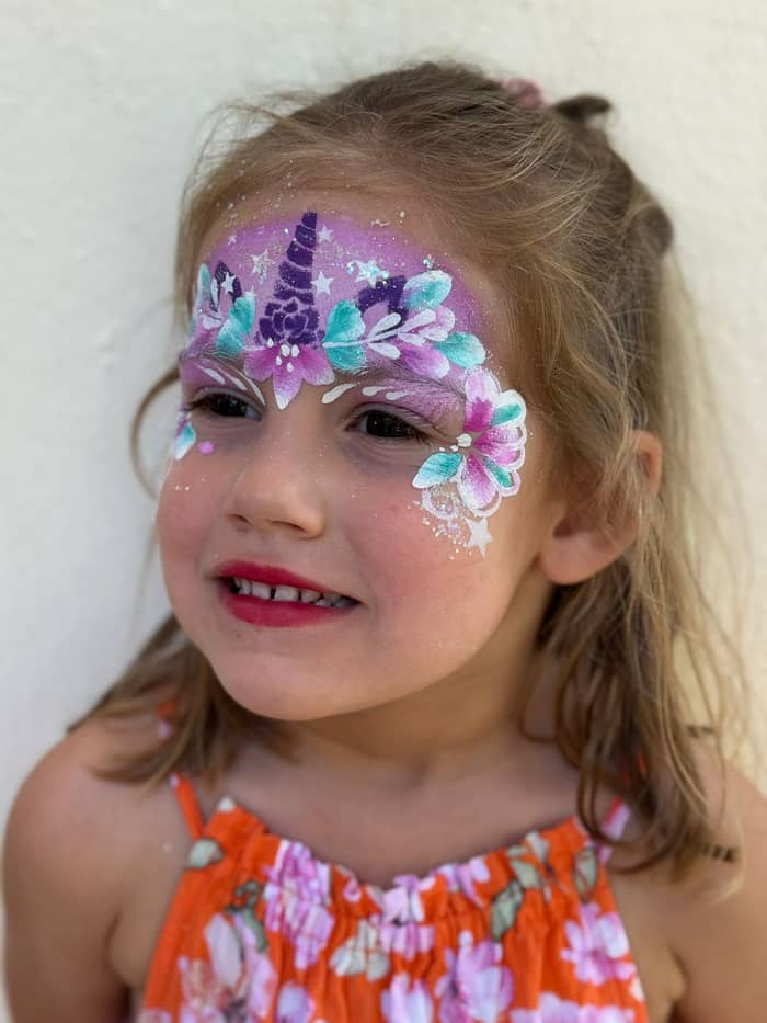 Maquillage de licorne fleuri sur le visage d'une petite fille